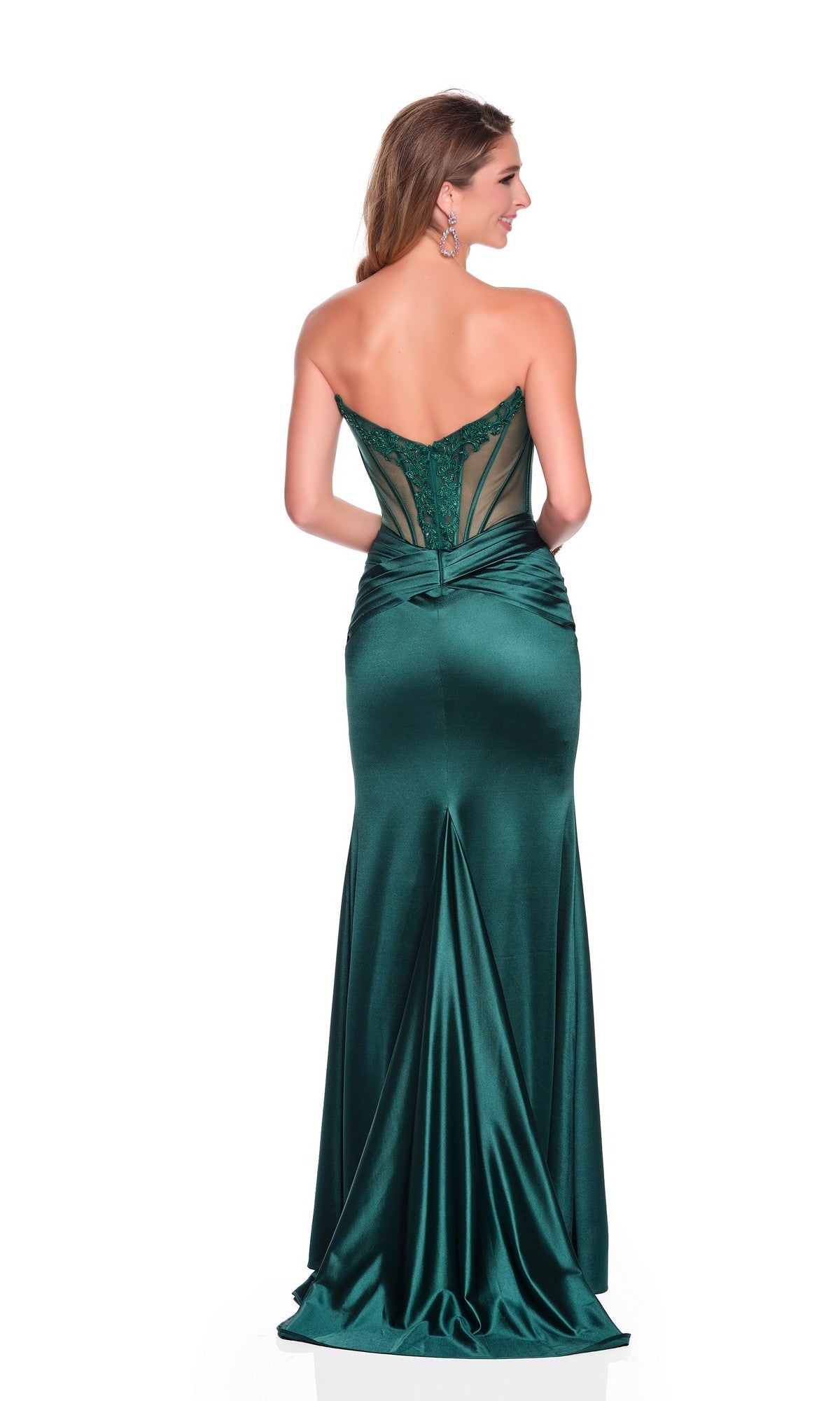 A woman faces away, showcasing the stunning fitted silhouette of the Dave and Johnny 12775 long prom dress, featuring a strapless emerald-green design with a sheer embroidered corset bodice and satin sheath skirt.